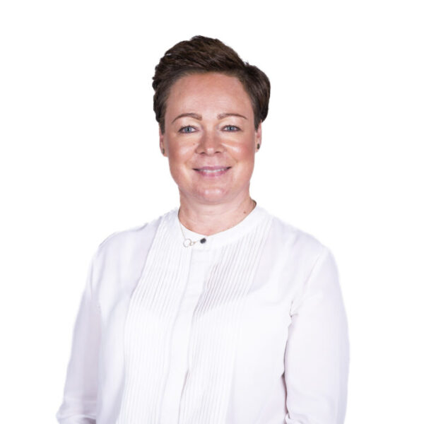 Portret uśmiechniętej kobiety z krótkimi ciemnymi włosami, ubranej w białą bluzkę, na jasnym tle.