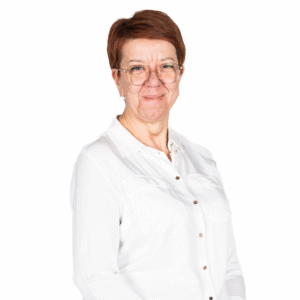 Portret kobiety z krótkimi rudymi włosami i w okularach, ubranej w jasną koszulę, na białym tle.